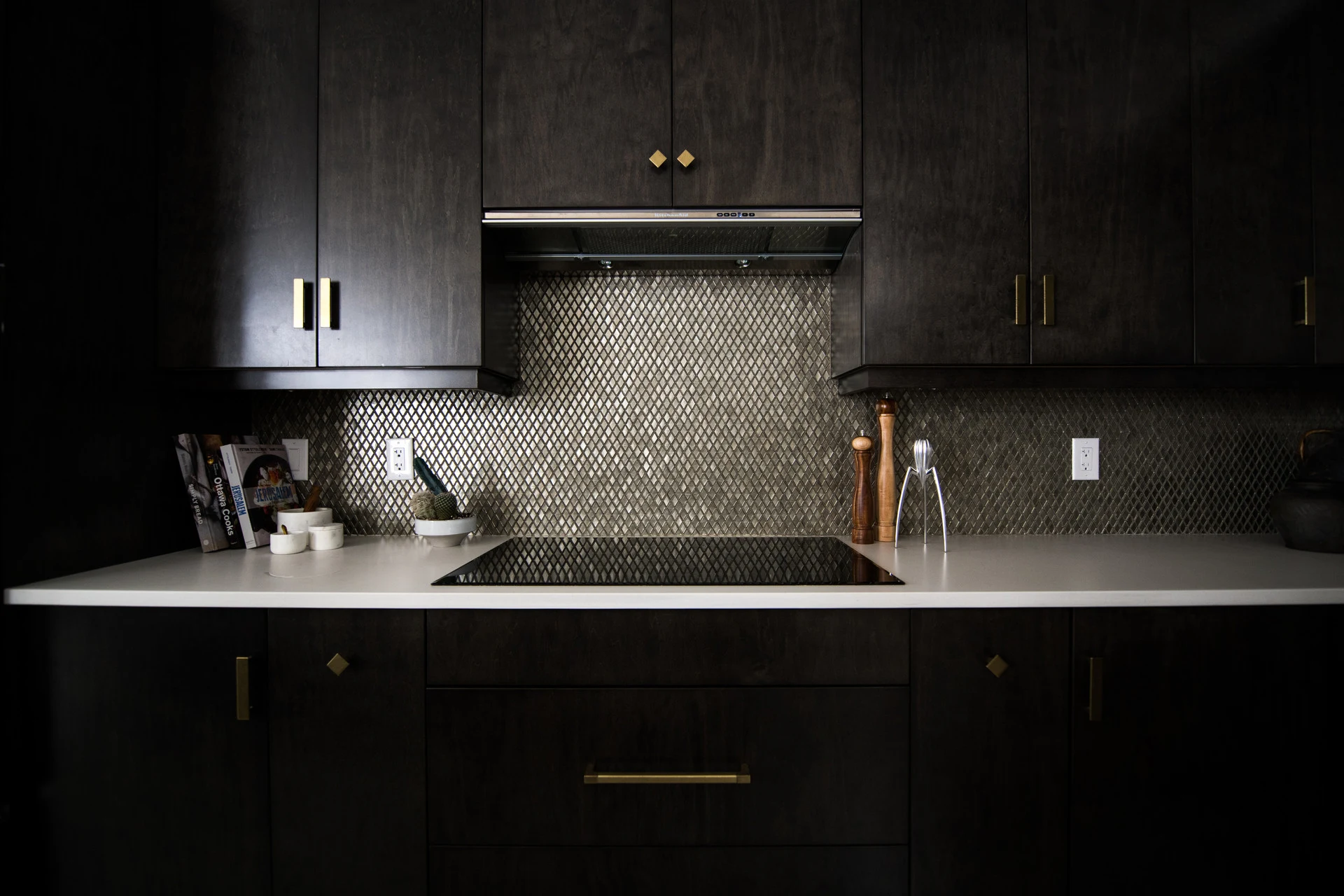 Matte black modern kitchen with brass hardware and white counters by Vamaylo